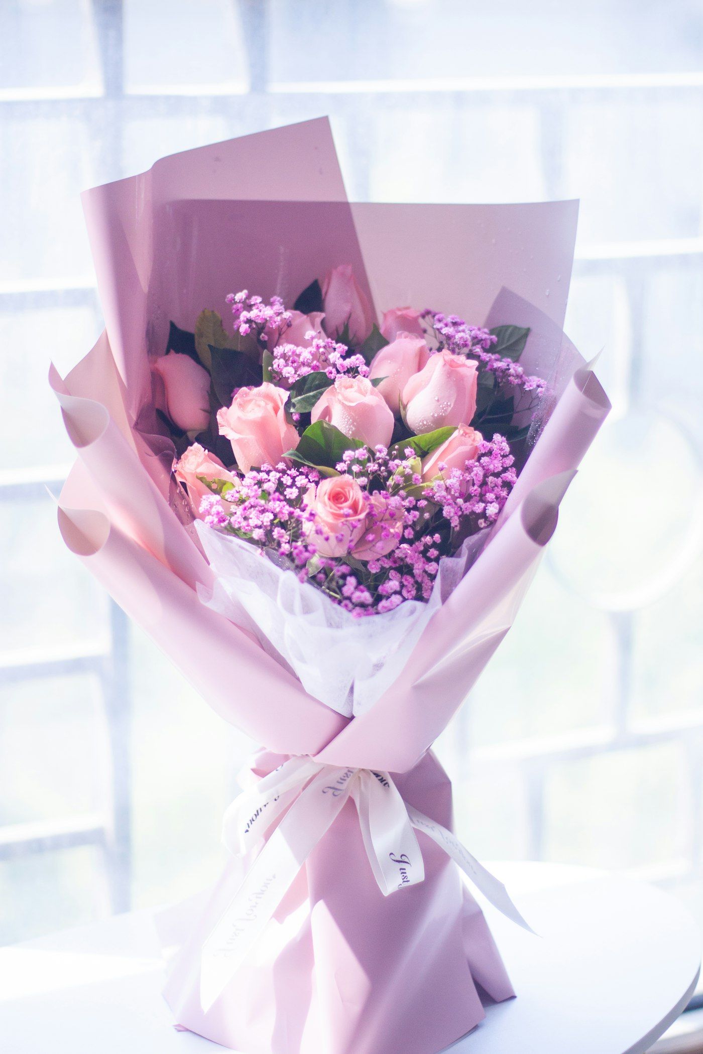 Bó hồng phấn xen baby tím gói giấy hồng pastel
